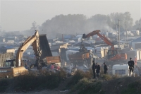 Εκσκαφέας κατεδαφίζει τα προσφυγικά παραπήγματα στο Καλαί