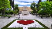 Μήνυμα Μπακογιάννη για Πρωτομαγιά μέσα από μια κόκκινη καρδιά από λουλούδια στο Σύνταγμα